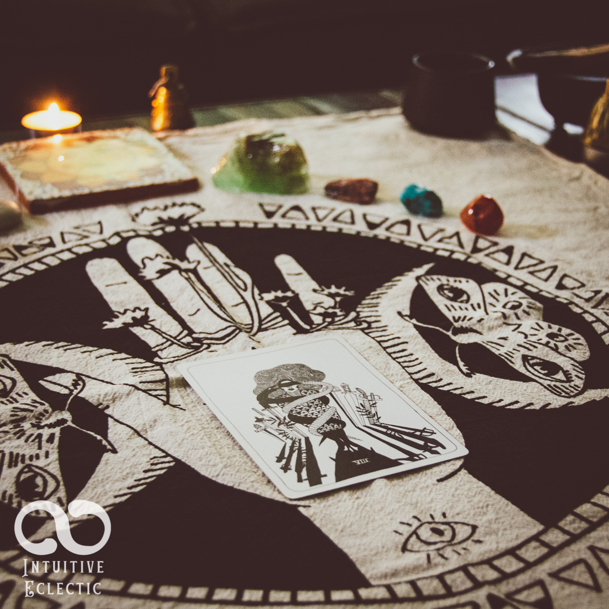 Altar cloth, candle, crystals and a single tarot card
